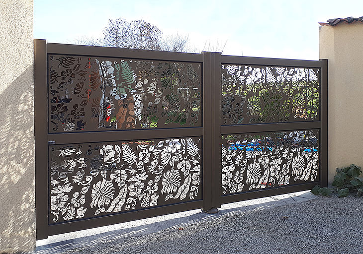 Portail battant aux motifs floraux en tôle découpée